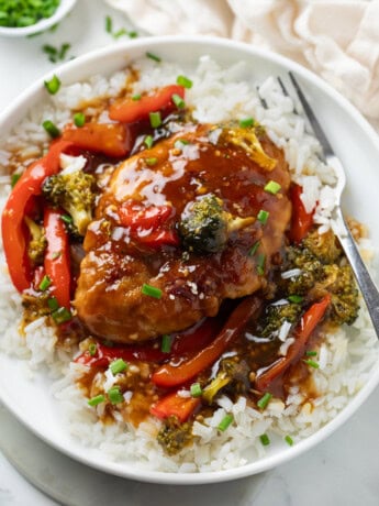 Honey Garlic Chicken on a bed of white rice with glaze and vegetables.