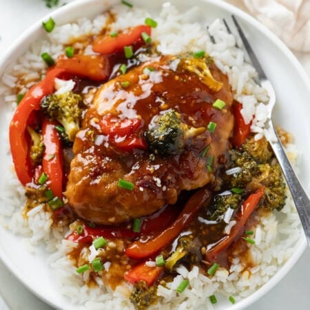 Honey Garlic Chicken on a bed of white rice with glaze and vegetables.