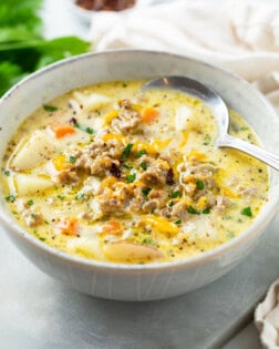 A bowl of Sausage Potato Soup with a spoon.