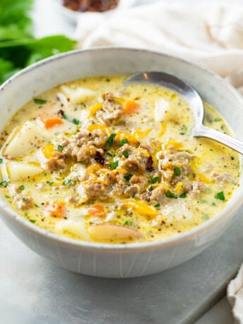 A bowl of Sausage Potato Soup with a spoon.