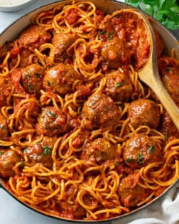 A large pot of Spaghetti and Meatballs with a spoon in it.