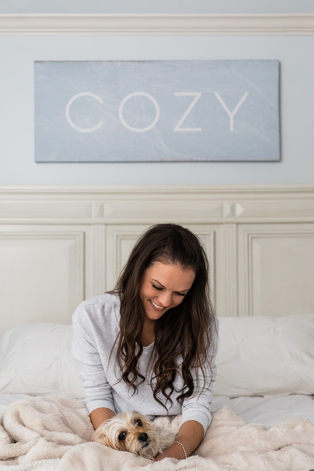 The Cozy Cook, Stephanie Melchione, in a cozy bed with her dog Toby.