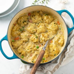 A Dutch oven filled with savory Chicken and Dumplings with vegetables and Chicken.