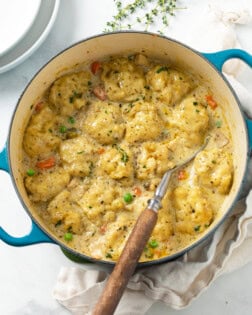 A Dutch oven filled with savory Chicken and Dumplings with vegetables and Chicken.