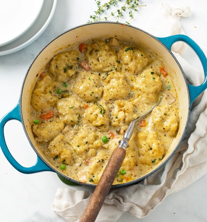 A Dutch oven filled with savory Chicken and Dumplings with vegetables and Chicken.