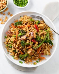 Ramen Noodle Stir Fry with Chicken and vegetables in sauce with a fork on the side.