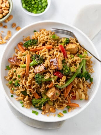 Ramen Noodle Stir Fry with Chicken and vegetables in sauce with a fork on the side.