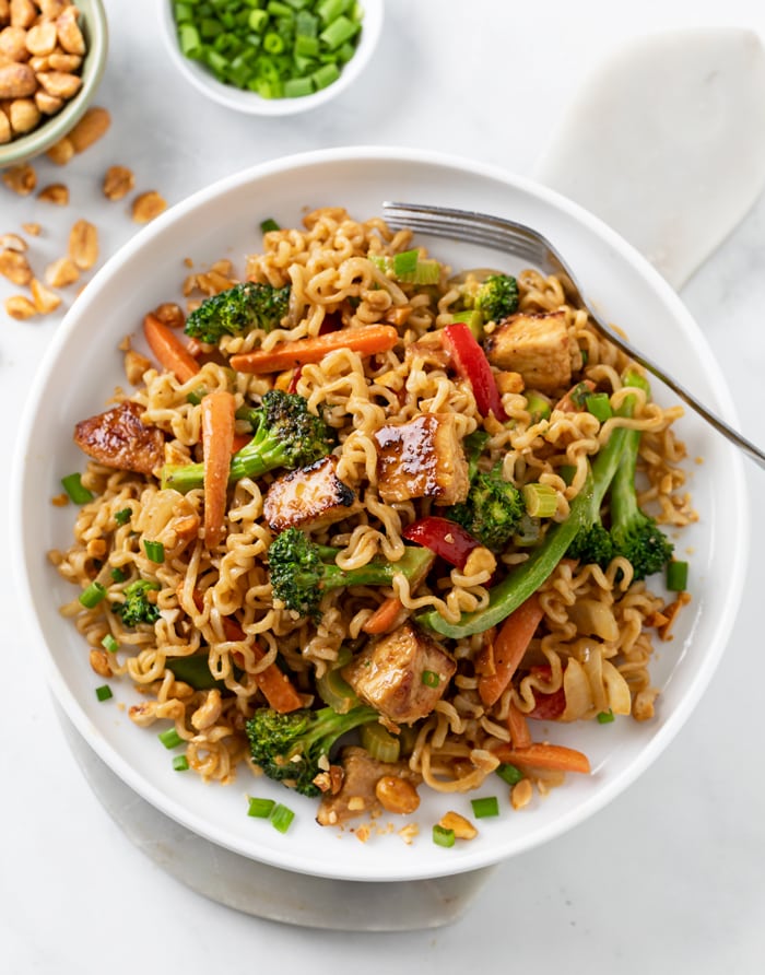 Ramen Noodle Stir Fry with Chicken and vegetables in sauce with a fork on the side.