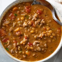 A bowl of Lentil Sausage Soup with diced tomatoes.