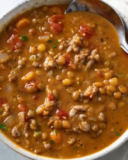 A bowl of Lentil Sausage Soup with diced tomatoes.