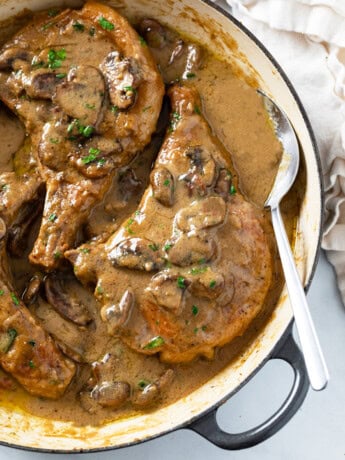 Mushroom Pork Chops in a skillet with gravy.