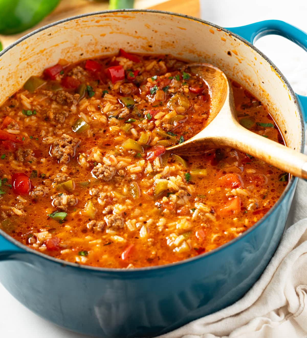 Stuffed Pepper Soup in a blue soup pot with a wooden spoon on the side.