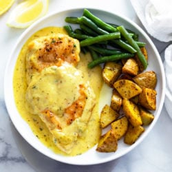 Honey Mustard Chicken on a white plate with green beans and roasted potatoes.