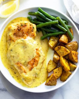 Honey Mustard Chicken on a white plate with green beans and roasted potatoes.