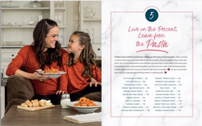 A mother and a daughter on the couch eating pasta in a chapter page of The Cozy Cookbook.