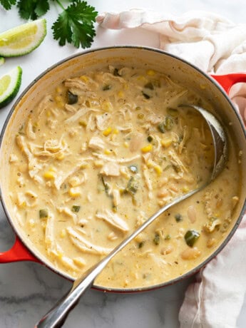 A soup pot filled with White Chicken Chili with a ladle in it.