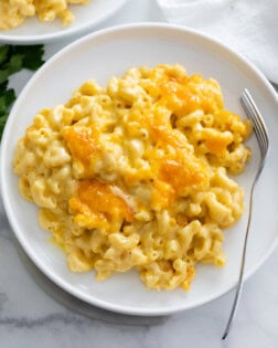 Baked Mac and Cheese on a white plate with a fork on the side.