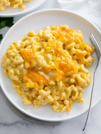 Baked Mac and Cheese on a white plate with a fork on the side.