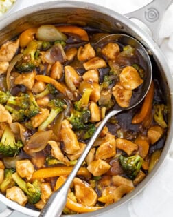 Chicken and Broccoli Stir Fry in a skillet with a spoon on the side.