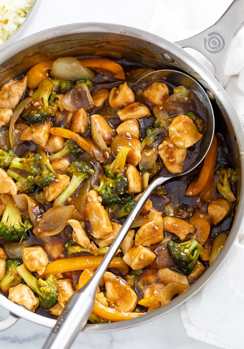 Chicken and Broccoli Stir Fry in a skillet with a spoon on the side.