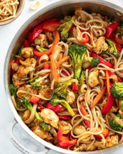 A skillet filled with Chicken Noodle Stir Fry with rice noodles, vegetables and sauce.