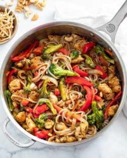 Chicken Noodle Stir Fry in a skillet with broccoli, bell peppers, chicken, and noodles.