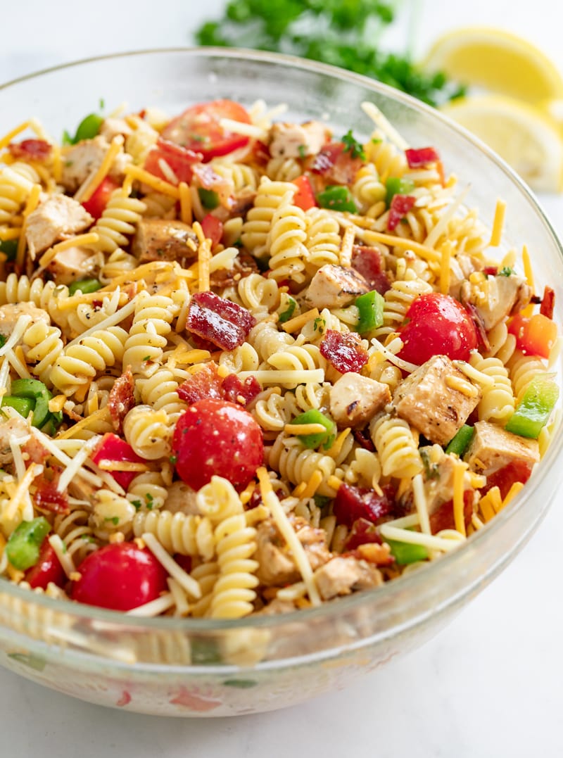 Chicken Pasta Salad in a glass bowl with chicken, bacon, tomatoes, bell peppers, and cheese.