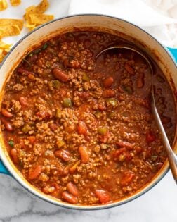 Chili in a Dutch oven with Fritos on the side.