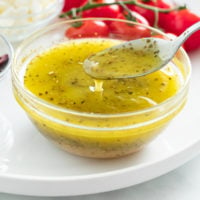 Greek Salad Dressing in a glass bowl with a spoon.