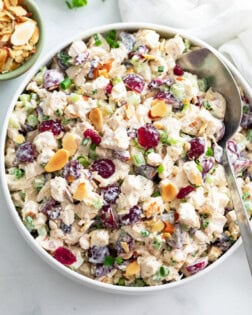 A big bowl of Chicken Salad with grapes, cranberries, sliced almonds, and more.