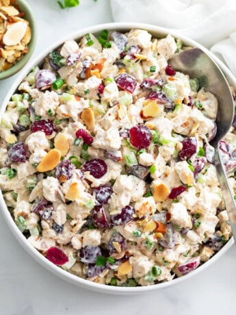 A big bowl of Chicken Salad with grapes, cranberries, sliced almonds, and more.