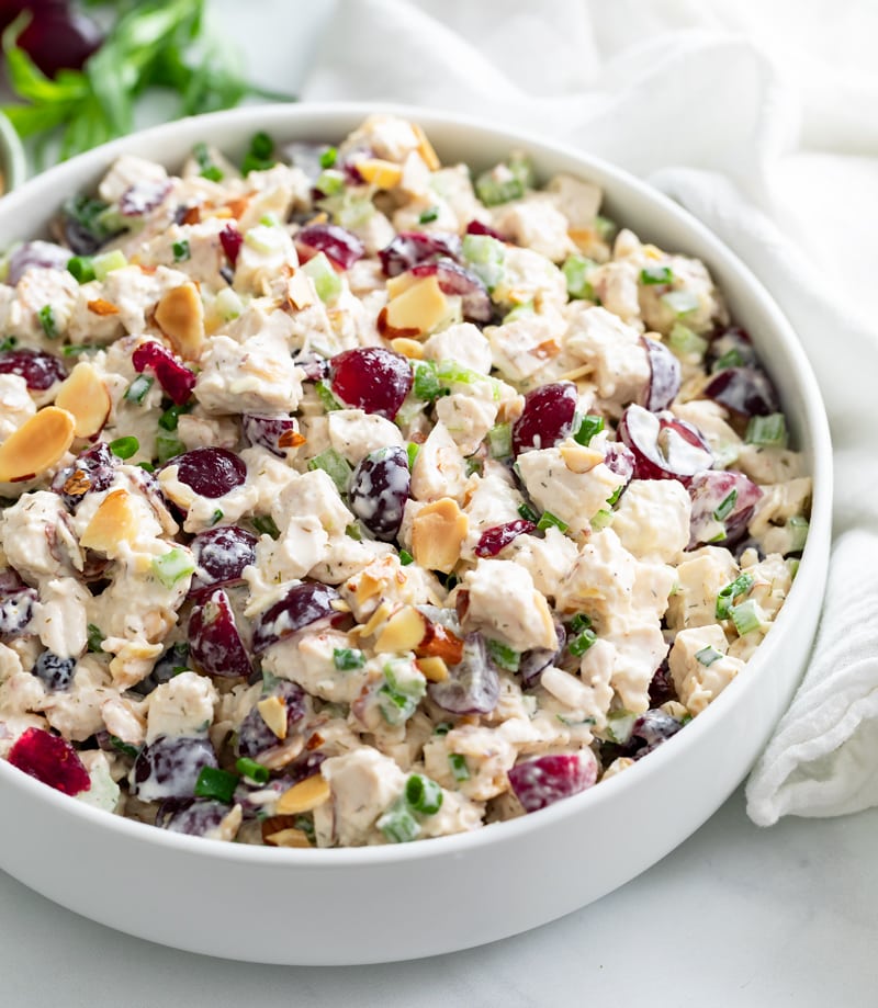 A white bowl of Chicken Salad with grapes, almonds, and chicken.