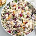A bowl of Chicken Salad with grapes, cranberries, almonds, and more.