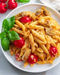 Caprese Pasta with fresh tomatoes and basil on a white plate.