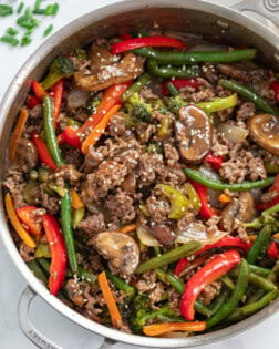 A skillet filled with Ground Beef Stir Fry with sesame seeds on top.