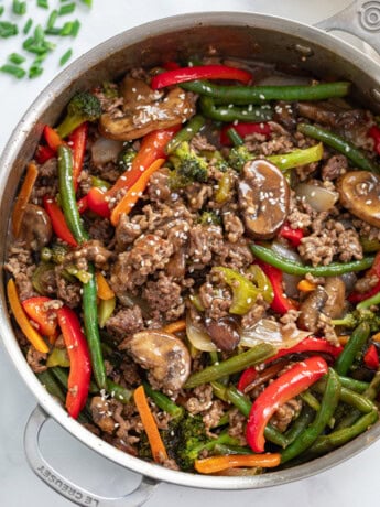 A skillet filled with Ground Beef Stir Fry with sesame seeds on top.