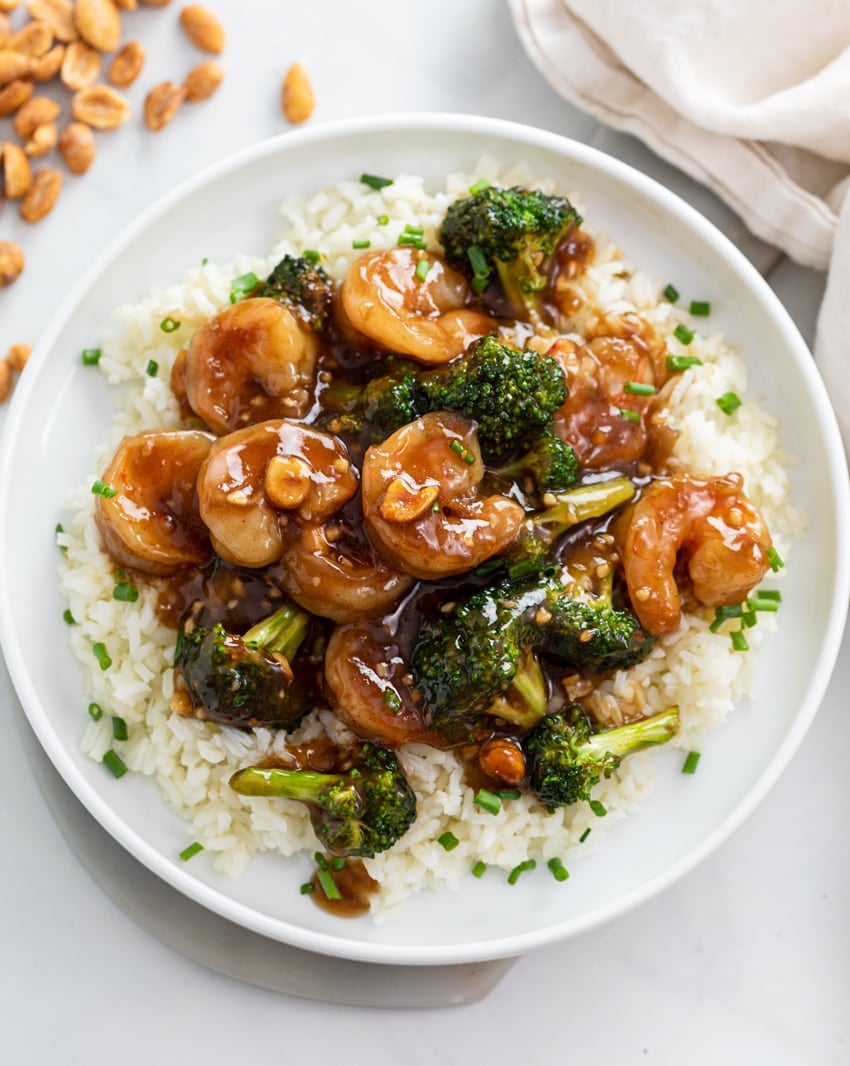 Honey Garlic Shrimp with Broccoli on a bed of rice on a white plate.