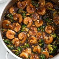 Honey Garlic Shrimp in a skillet with broccoli and brown sauce with chopped peanuts.