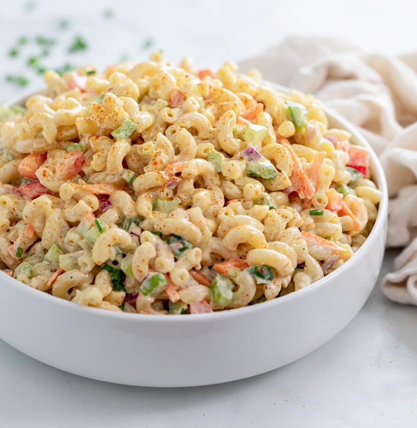 Macaroni Salad in a white bowl with paprika on top.