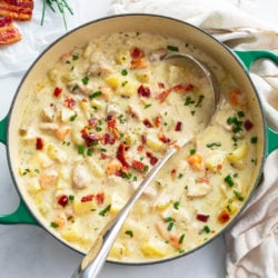 A soup pot filled with Creamy Chicken Potato Soup with bacon and chives on top.
