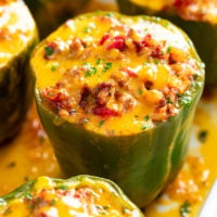 Stuffed Bell Peppers in a casserole dish with a meat filling and cheese on top.