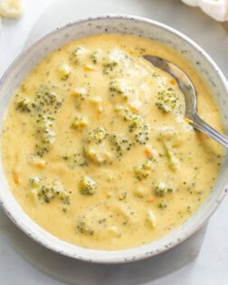 A bowl of Broccoli Cheese Soup with a spoon in it.