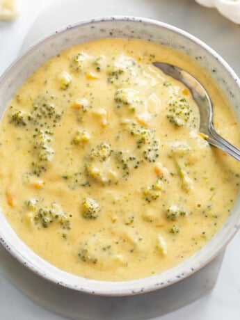 A bowl of Broccoli Cheese Soup with a spoon in it.