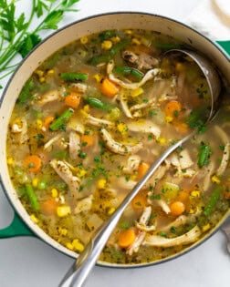 Chicken Vegetable Soup in a green soup pot with a ladle.