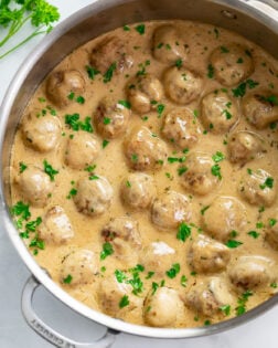 Swedish Meatballs and sauce in a skillet with freshly chopped parsley on top.