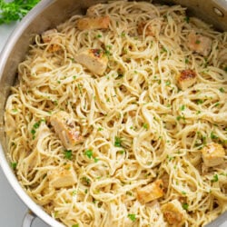 Angel Hair Pasta with Chicken in a large skillet with parsley on top.