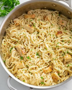 Angel Hair Pasta with Chicken in a large skillet with parsley on top.