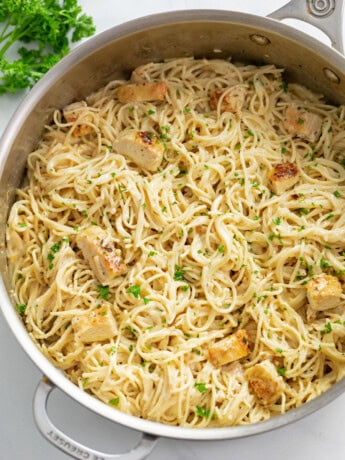 Angel Hair Pasta with Chicken in a large skillet with parsley on top.