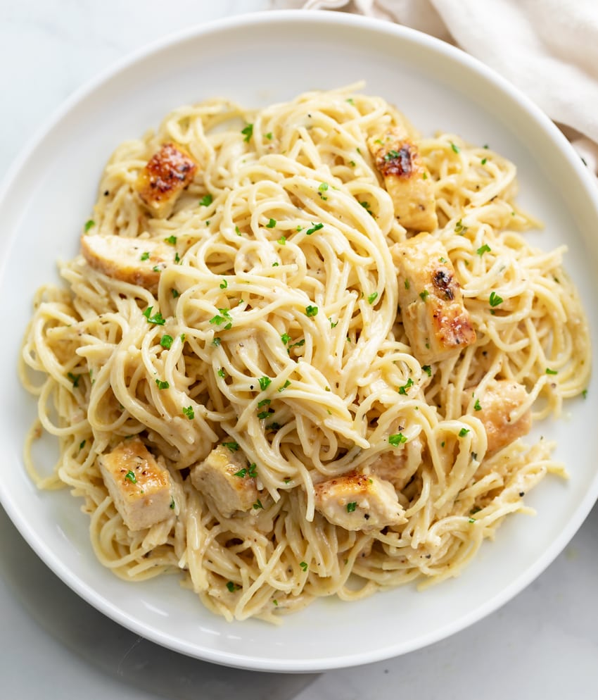 A white plate topped with Angel Hair Pasta with Chicken.