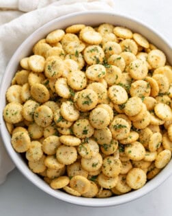 A white bowl filled with Ranch Oyster Crackers with seasonings.